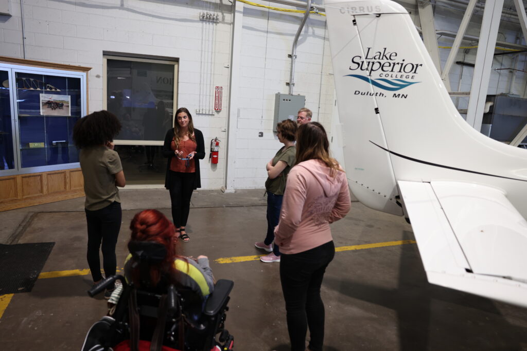 A group tours an aircraft hangar at Lake Superior College in Duluth
